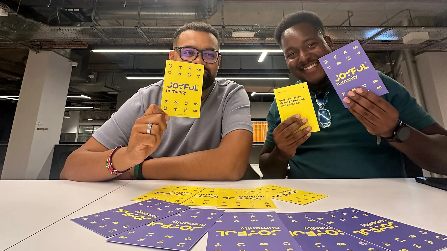 Bejay and Tom holding up the Joyful cards